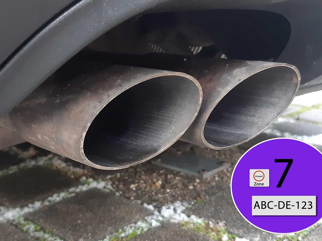 Gases de escape de un coche junto a la etiqueta medioambiental EU7