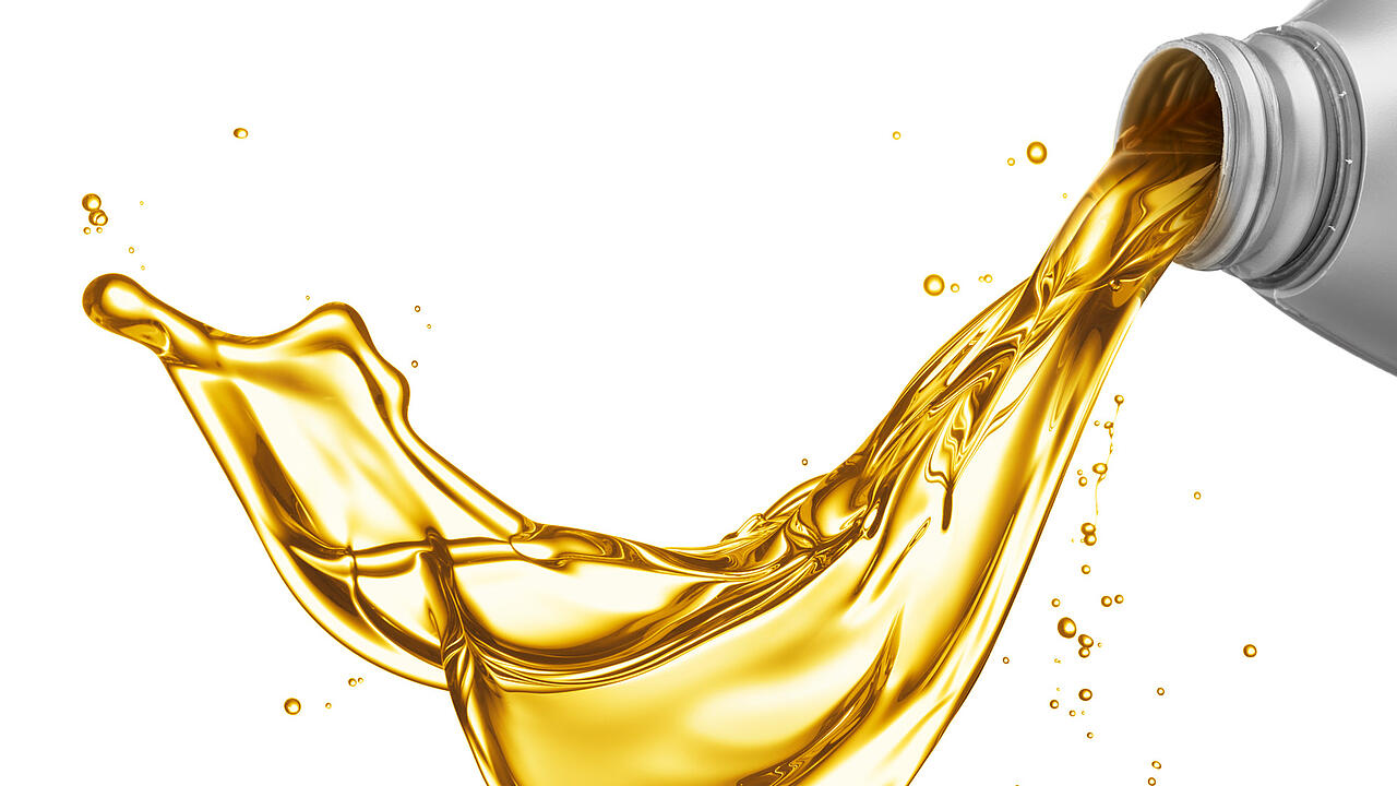 De una botella gris sale a borbotones aceite de motor amarillo