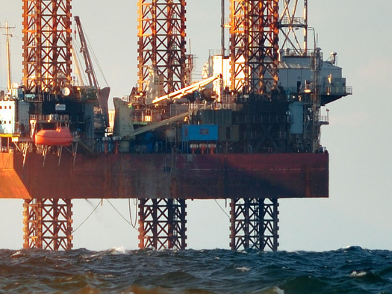 Plataformas petrolíferas en el mar con espuma de las olas en primer plano