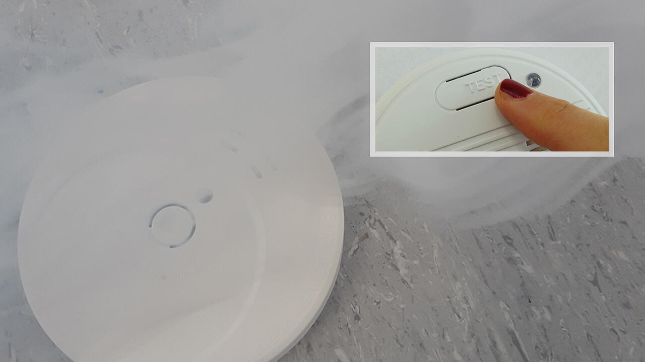 Detector de humo con niebla; imagen pequeña en la que se ve un dedo sobre el botón de prueba