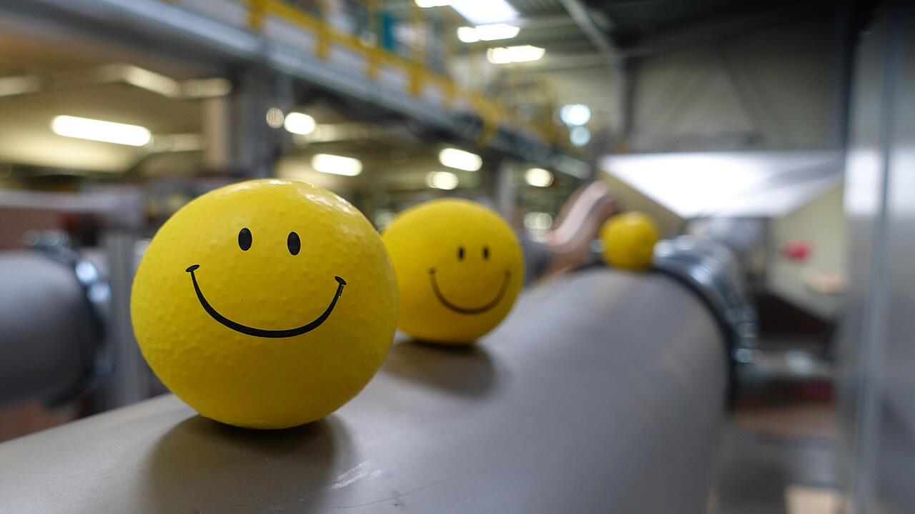 Nave de producción con bolas amarillas con caras sonrientes en el canal de pruebas