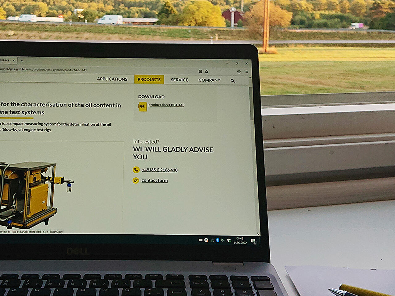 Situación de trabajo: Página web de Topas en el portátil, con un bolígrafo y un bloc de notas frente a una ventana luminosa