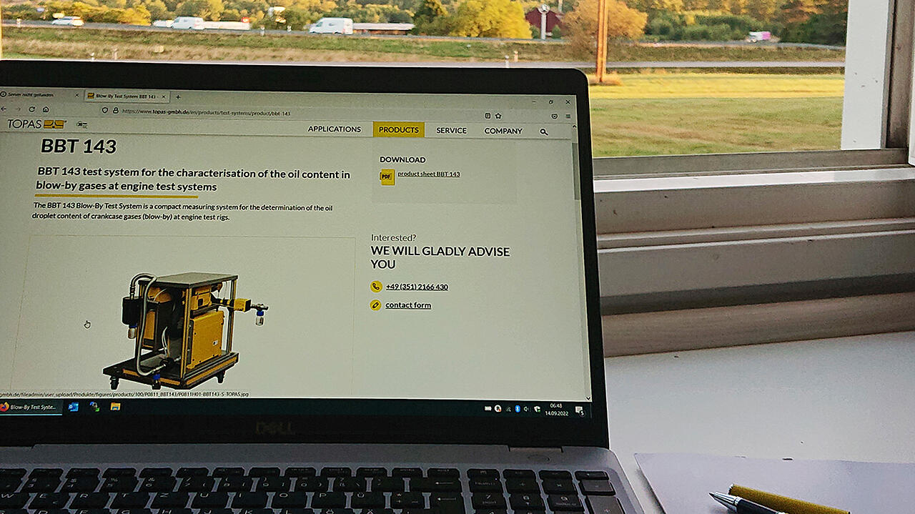 Situación de trabajo: Página web de Topas en el portátil, con un bolígrafo y un bloc de notas frente a una ventana luminosa